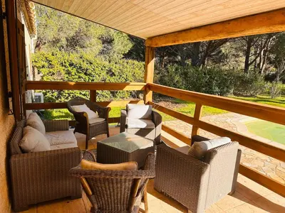a screened in porch with chairs and tables at Charmante Villa Privée avec Piscine in Porto-Vecchio
