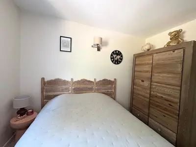 a bedroom with a bed and a wooden cabinet at Mini villa Stagnola in Pietrosella