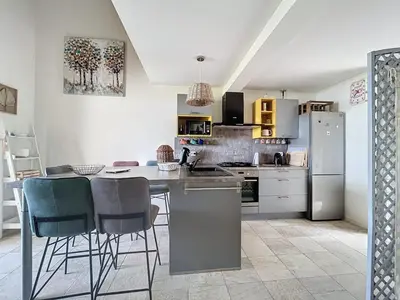 a kitchen with a refrigerator and a table and chairs at Mini villa Stagnola in Pietrosella