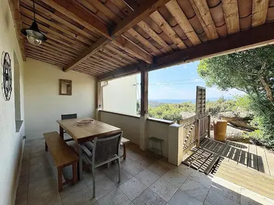 a dining room with a table and a large window at Mini villa Stagnola in Pietrosella