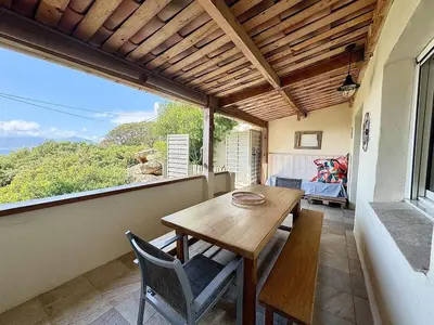 a dining room with a table and chairs on a balcony at Mini villa Stagnola in Pietrosella