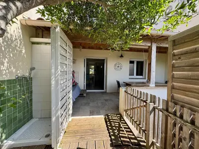 a walkway leading to a house with a wooden fence at Mini villa Stagnola in Pietrosella