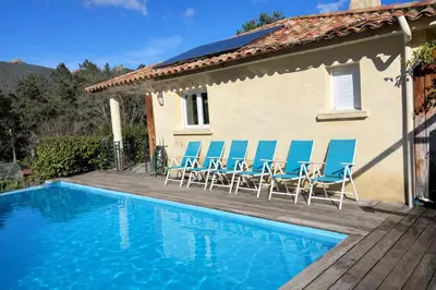 a villa with a swimming pool and chairs on a deck at Villa Mare E Muntagna in Porto-Vecchio