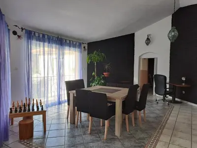 a dining room with a wooden table and chairs at Villa Mare E Muntagna in Porto-Vecchio