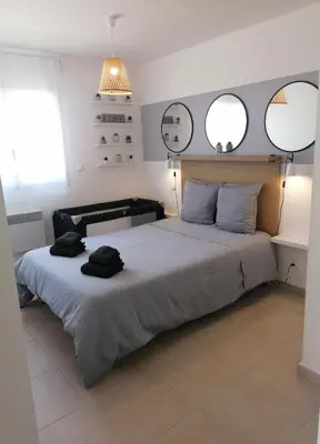 a bedroom with a large bed with two mirrors on the wall at Petit havre de paix au bord de la mer in Linguizzetta