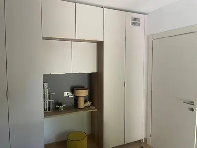 a white kitchen with white cabinets and a yellow bucket at Santa Giulia, Résidence Cala Sultana Numero 40 in Porto-Vecchio