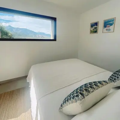 two beds in a room with a window at Stone House Between Porto-Vecchio And Bonifacio in Figari