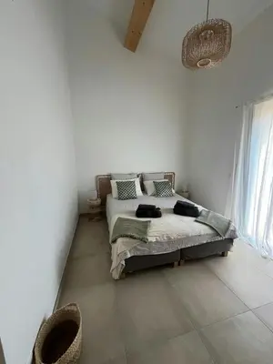 a bedroom with a bed in a white room at Stone House Between Porto-Vecchio And Bonifacio in Figari