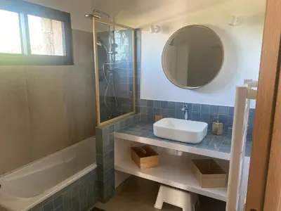 a bathroom with a sink and a mirror and a tub at Stone House Between Porto-Vecchio And Bonifacio in Figari