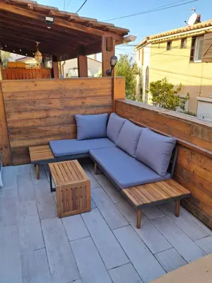 a blue couch and two benches on a patio at Studio maisonnette au bord de belle plage d'Agosta in Albitreccia