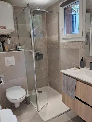 a bathroom with a shower and a toilet and a sink at Studio maisonnette au bord de belle plage d'Agosta in Albitreccia