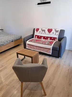 a living room with a couch and a chair and a table at Studio maisonnette au bord de belle plage d'Agosta in Albitreccia