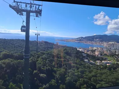 a gondola ride in the sky over a city at Studio maisonnette au bord de belle plage d'Agosta in Albitreccia