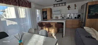 a kitchen and living room with a table and chairs at T3 Cosy Ajaccio in Ajaccio