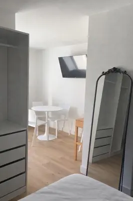 a white room with a table and a mirror at Studio climatisé avec terrasse privative in Corte