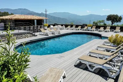 a pool with chaise lounge chairs and a deck at Studio climatisé avec terrasse privative in Corte