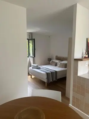 a room with a bed and a table and chairs at Studio climatisé avec terrasse privative in Corte