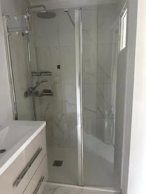 a shower with a glass door in a bathroom at Studio climatisé avec terrasse privative in Corte