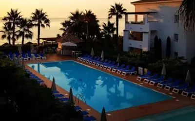 a large swimming pool with chairs and a building at Entre mer et montagne in San-Nicolao