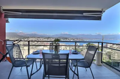 a table and chairs on a balcony with a view at Casa Simona - View of the Gulf of Ajaccio in Ajaccio