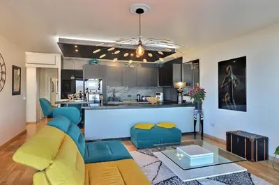 a living room with a couch and a kitchen at Casa Simona - View of the Gulf of Ajaccio in Ajaccio