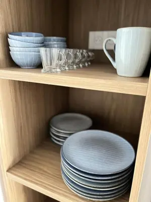 a shelf with plates and bowls and a cup at Rare T2 New, Waterfront in Porticcio