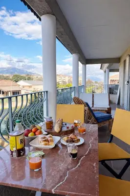 a breakfast table on a balcony with a view at Appart cosy - Lumineux avec terrasse in Borgo
