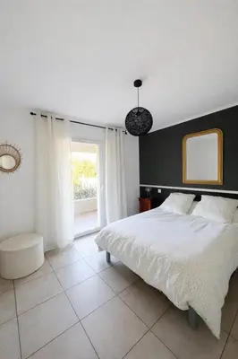 a bedroom with a white bed and a window at Appart cosy - Lumineux avec terrasse in Borgo
