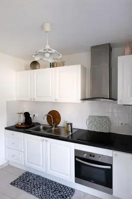 a kitchen with white cabinets and a sink at Appart cosy - Lumineux avec terrasse in Borgo