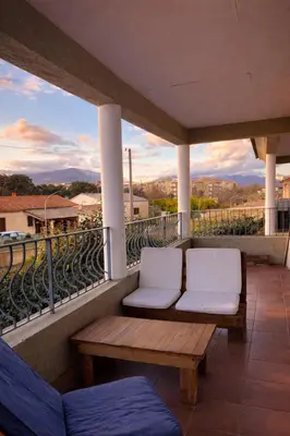 two white chairs on a balcony with a view at Appart cosy - Lumineux avec terrasse in Borgo