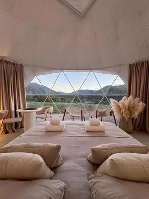 a bedroom with a large bed with a large window at Les Dômes du Moulin in Urtaca
