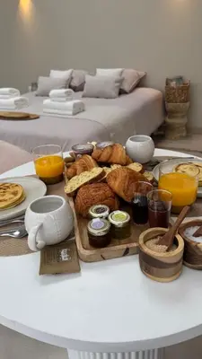 a table with a tray of bread and orange juice at Les Dômes du Moulin in Urtaca