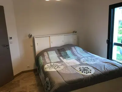 a bedroom with a bed with a quilt on it at Villa proche de St Florent Corse in Oletta