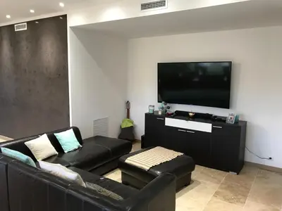 a living room with a couch and a flat screen tv at Villa proche de St Florent Corse in Oletta