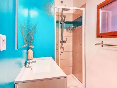 a blue bathroom with a sink and a shower at Holiday Home Chalet Terra Tramandera by Interhome in Calcatoggio