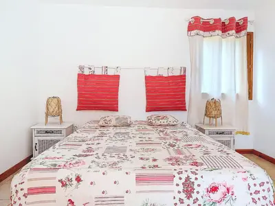 a bedroom with a large bed with red pillows at Holiday Home Maisonnette Terra Tramandera by Interhome in Calcatoggio