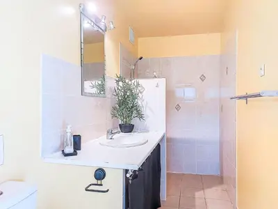 a bathroom with a sink and a mirror and a shower at Holiday Home Maisonnette Terra Tramandera by Interhome in Calcatoggio