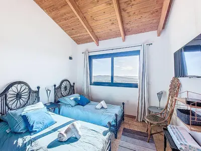 a bedroom with two beds and a large window at Villa La Dorianzza by Interhome in Porto-Vecchio