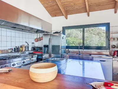 a large kitchen with a wooden table in it at Villa La Dorianzza by Interhome in Porto-Vecchio