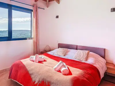 a bedroom with a large bed with two pillows on it at Villa La Dorianzza by Interhome in Porto-Vecchio