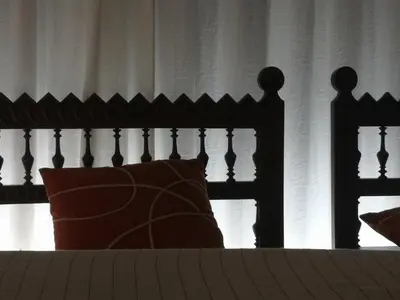 a bed with a black headboard and a red pillow at Casa Una Storia in Sartène