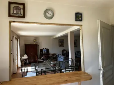 a dining room with a glass table and a clock on the wall at Holiday Home Haus in der Nähe von Meer und Bergen- atemberaubende Aussicht- by Interhome in Calcatoggio