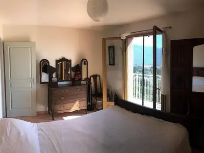 a bedroom with a bed and a dresser and a window at Holiday Home Haus in der Nähe von Meer und Bergen- atemberaubende Aussicht- by Interhome in Calcatoggio