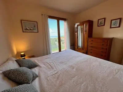 a bedroom with a large white bed and a window at Holiday Home Haus in der Nähe von Meer und Bergen- atemberaubende Aussicht- by Interhome in Calcatoggio