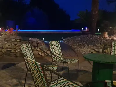 two chairs and a table and a stone wall at night at Holiday Home Exklusivität Korsika- Steinhaus mit Charme by Interhome in Santa-Lucia-di-Moriani