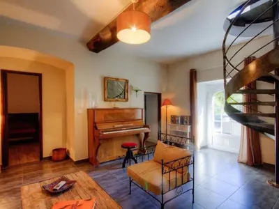 a living room with a piano and a couch at Holiday Home Exklusivität Korsika- Steinhaus mit Charme by Interhome in Santa-Lucia-di-Moriani