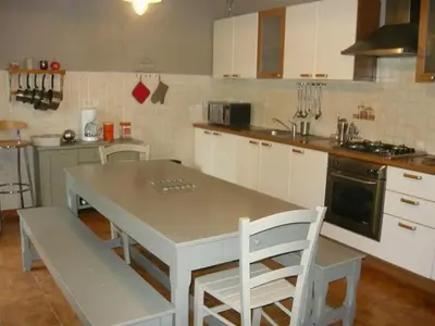 a kitchen with a table and chairs in it at Holiday Home Exklusivität Korsika- Steinhaus mit Charme by Interhome in Santa-Lucia-di-Moriani