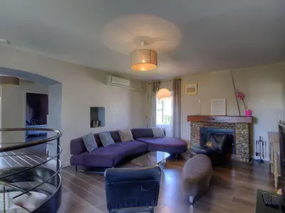 a living room with a purple couch and a fireplace at Holiday Home Exklusivität Korsika- Steinhaus mit Charme by Interhome in Santa-Lucia-di-Moriani