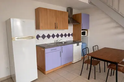 a kitchen with a table and a white refrigerator at Appartement Duplex 6 personnes - Soléa 204 - Vue Mer in Serra-di-Ferro