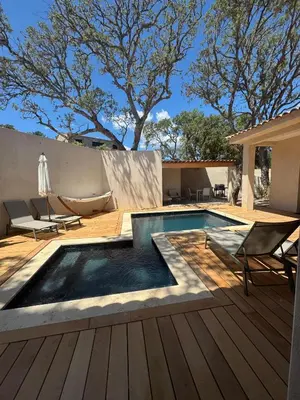 a swimming pool on a wooden deck with chairs at Magnifique villa 4 chambres saint lucie de porto Vecchio in Zonza